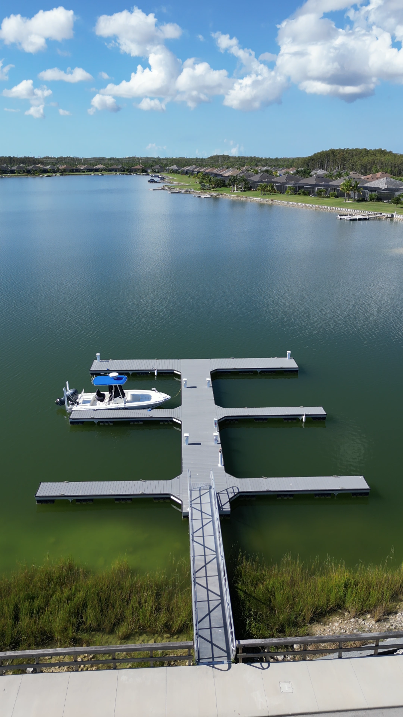 Aerial view of a residential community dock extending over a calm lake